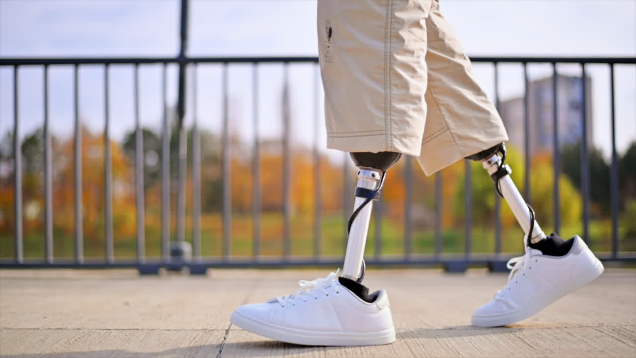 Slow motion view of a walking man with prosthetic legs and white sneakers