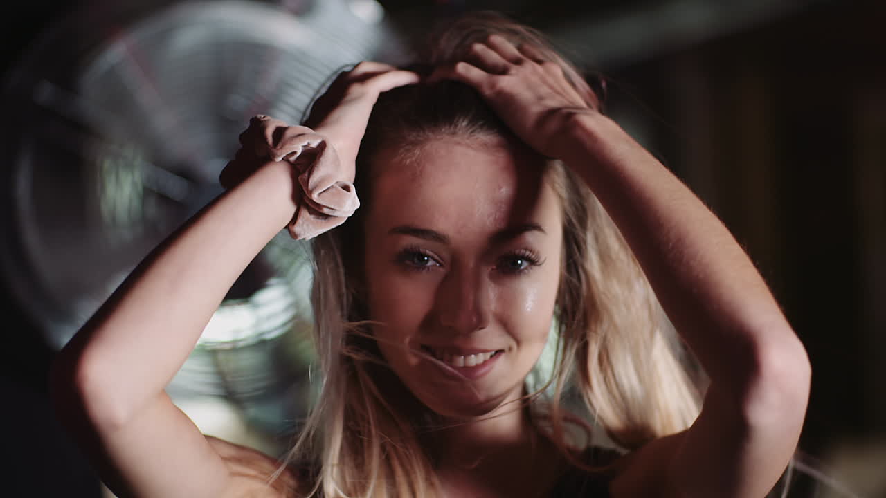 cámara lenta de atleta femenina atractiva sonriente moviendo las manos a través del cabello en el club de salud 6