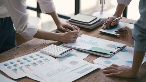 business professionals working together at office desk, hands close up pointing out financial data on a report, teamwork concept. financial and investment.