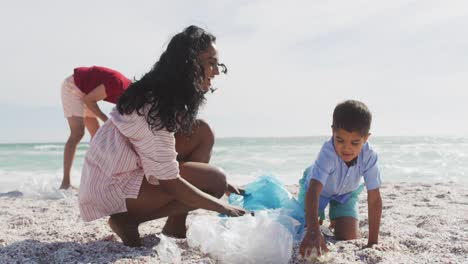 Glückliche-Hispanische-Familie-Sammelt-Müll-Am-Strand