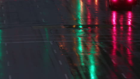 Slow-mo-of-a-person-with-an-umbrella-crossing-a-wet-New-York-Manhattan-main-street-at-night-with-traffic,-in-winter-with-snow