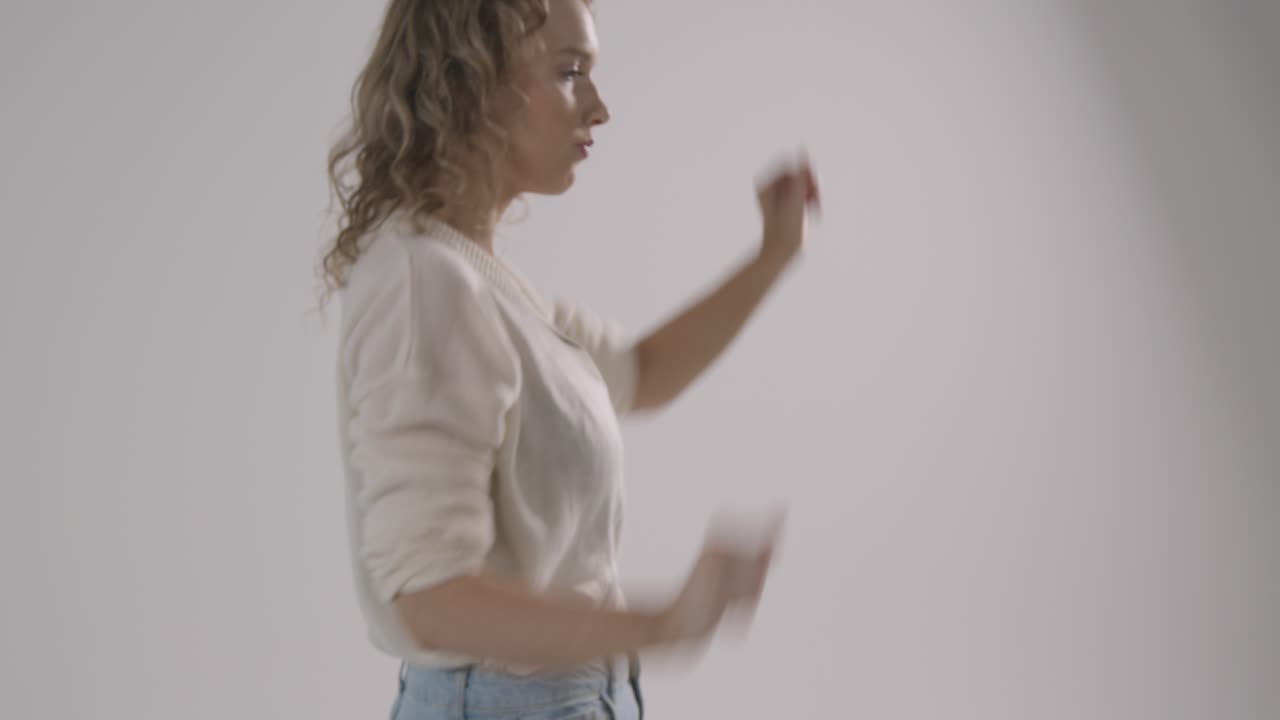 foto de estudio de una joven que se divierte bailando con fondo blanco