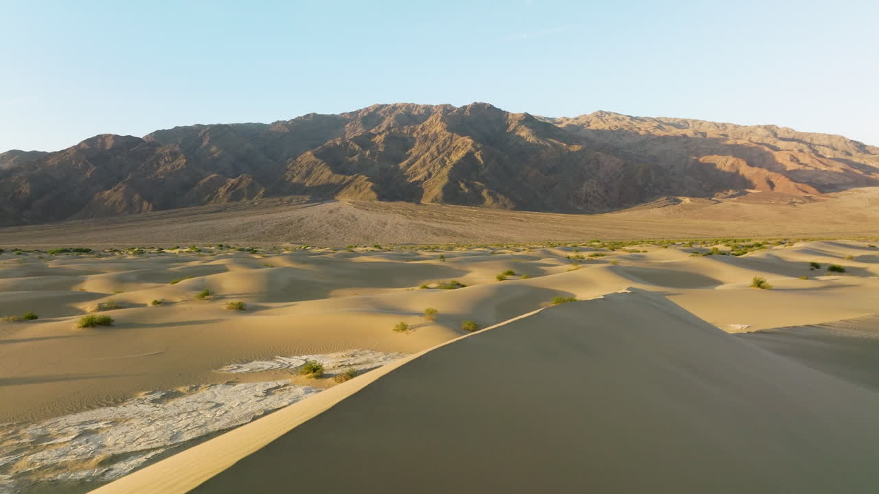 Vista panoramica del paesaggio del Parco Nazionale della Valle della Morte con una ragazza che cammina su una cima di duna di sabbia nella California orientale, USA