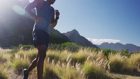 Hombre-Afroamericano-Corriendo-A-Campo-Traviesa-En-El-Campo-En-Una-Montaña