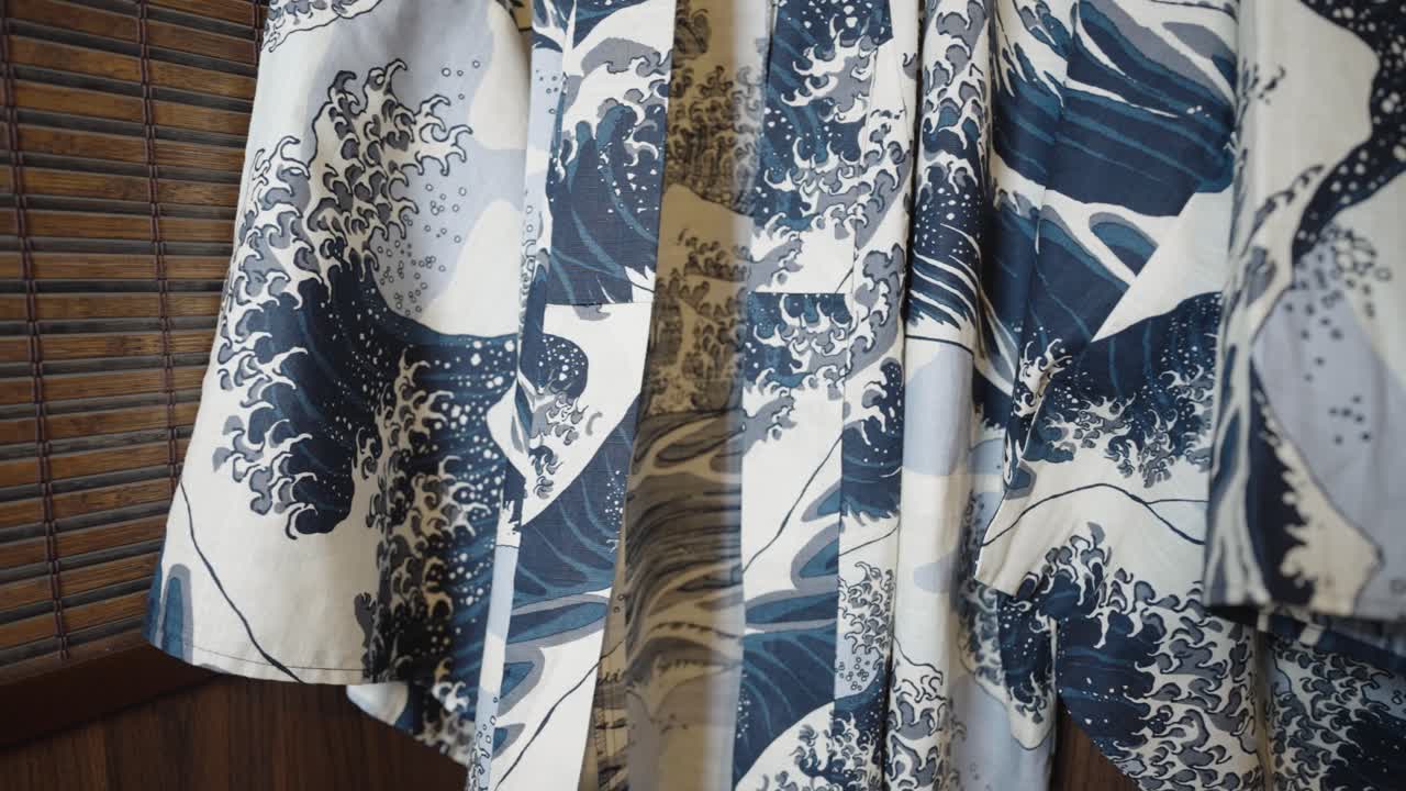 cacerola en el kimono que cuelga delante de una pared de madera japonesa - vestido con el patrón de la gran ola de kanagawa