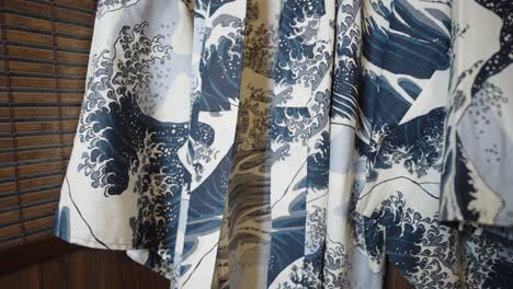 pan on the kimono hanging in front of a japanese wooden wall - dress with the great wave of kanagawa pattern