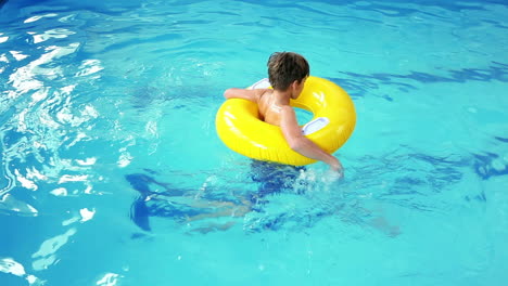 Un-Niño-Lindo-Usando-Un-Anillo-Inflable-En-La-Piscina.