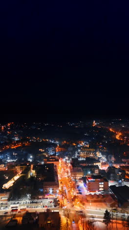 flight above the night view of the cozy town in winter. christmas season in zakopane, poland with festive illumination. vertical video.