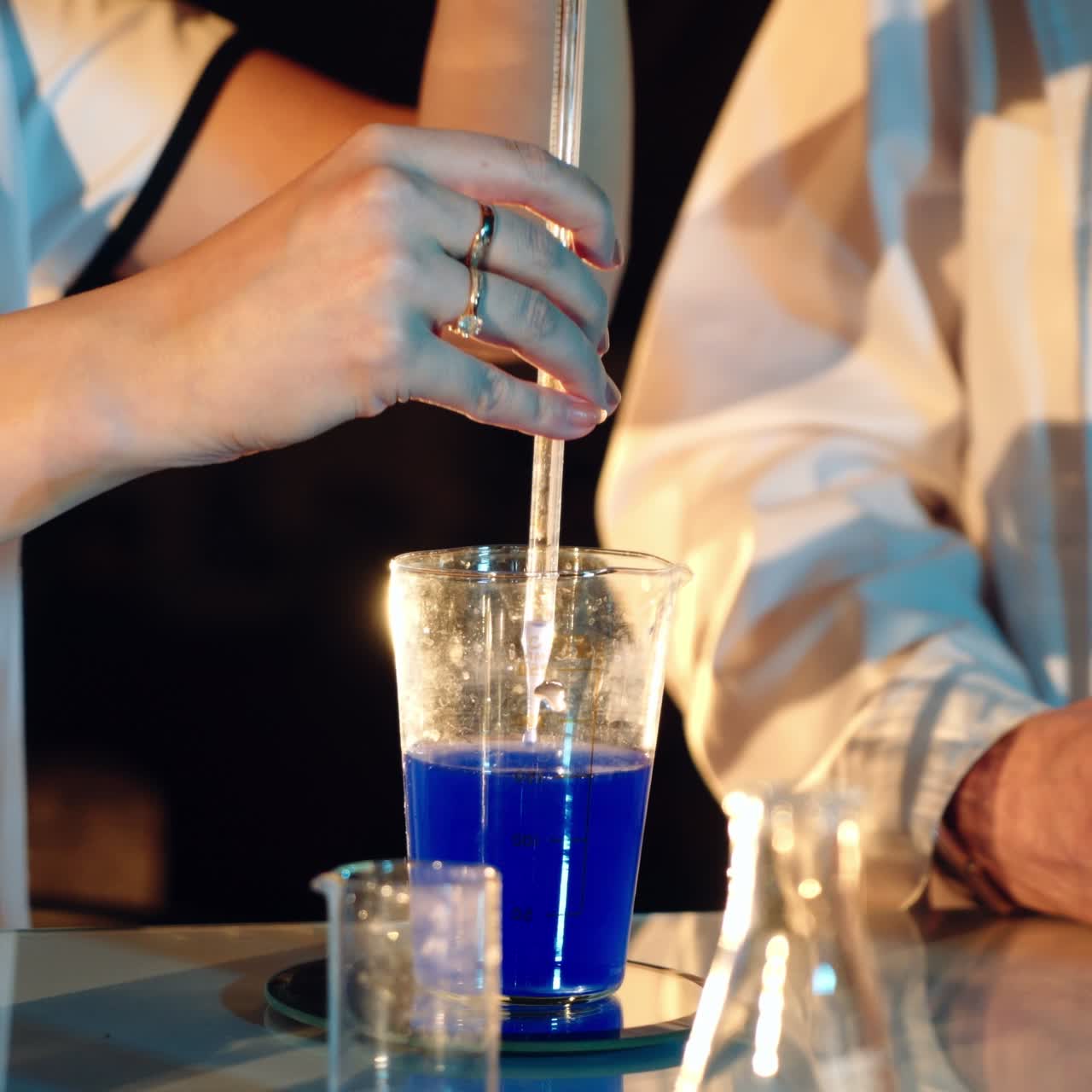 Two scientists are working in laboratory. Young female and male researcher are doing investigations with test tubes.