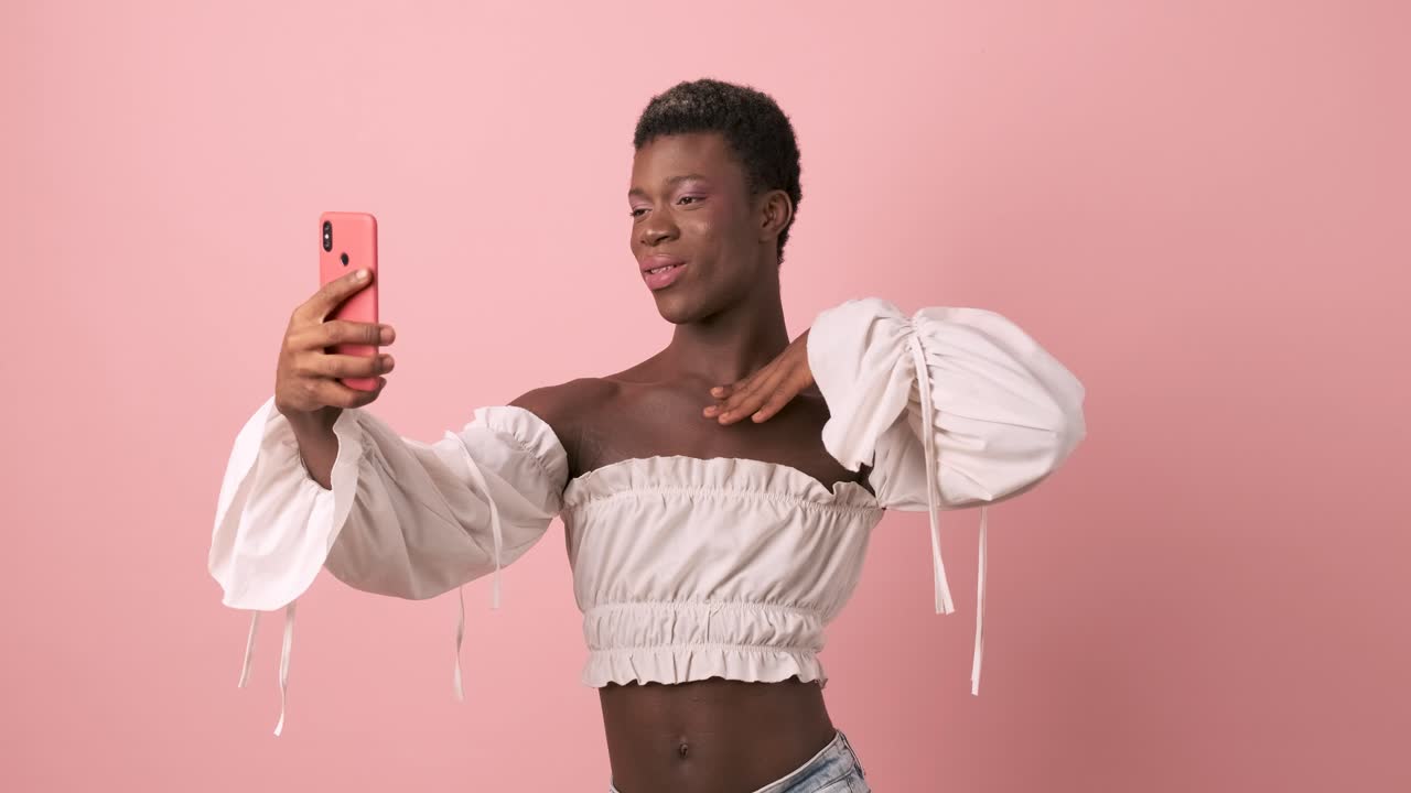 Persona transgender africana sensuale che si fa dei selfie con il telefono cellulare.