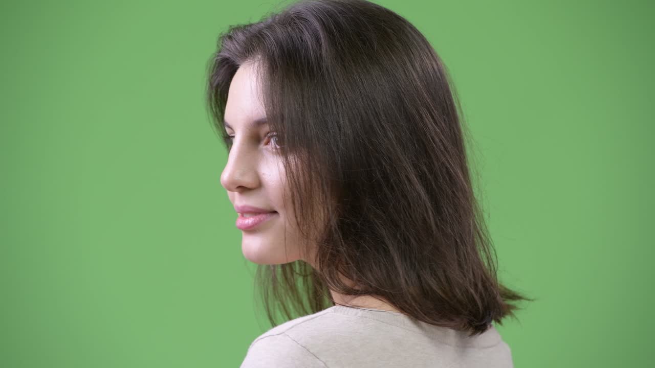 Young happy beautiful woman looking back