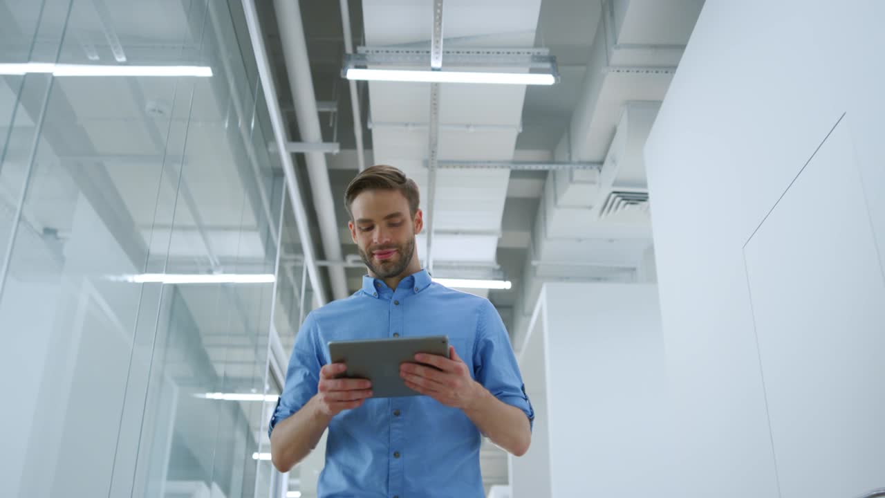 Smiling businessman waving hands while going through modern office