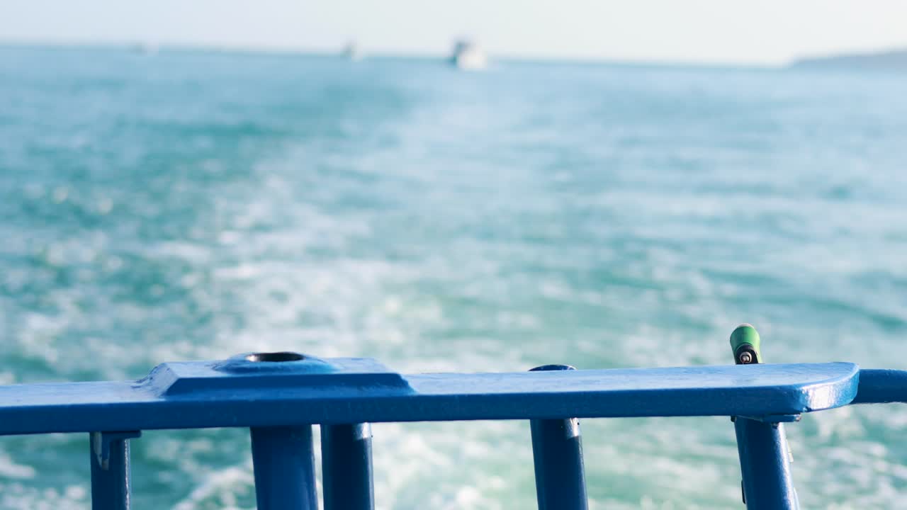 A fishing boat moves through Phuket's blue waters, creating a serene wake under bright daylight
