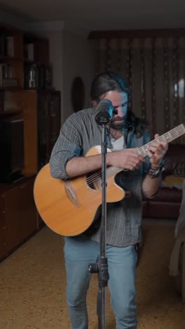 emotional male musician singing into microphone with guitar