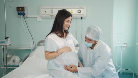 pregnant woman receiving care from a doctor in a hospital room