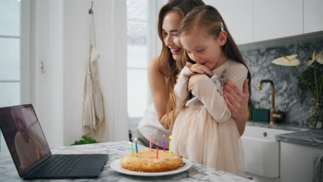 child birthday videocall celebration. girl holding toy preparing blowing candles