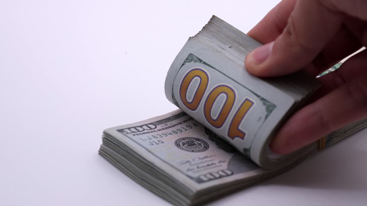 Counting a stack of $100 bills. Slow motion close-up
