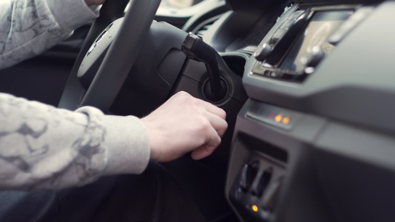 Starting car with keys in hand, side closeup view from inside