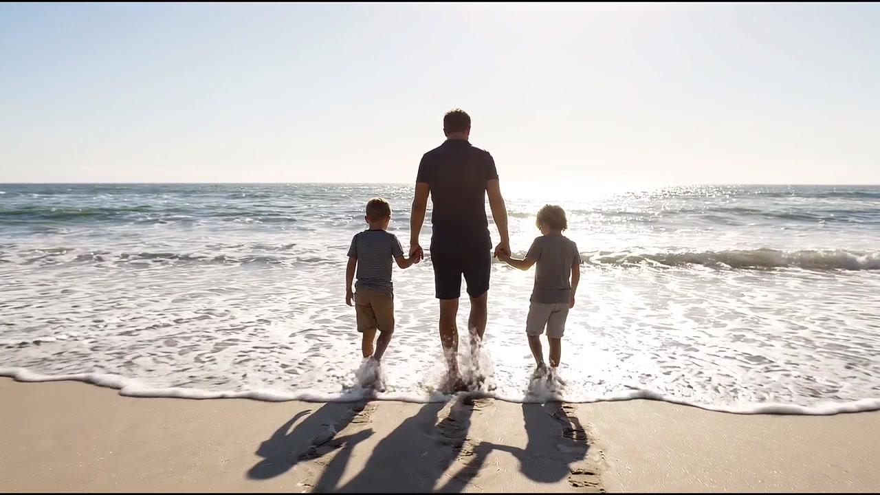 Padre che cammina sulla spiaggia con due bambini che si tengono per mano, godendosi una scena marittima soleggiata.