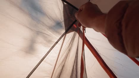 point-of-view shot from inside a camping tent showing a hiker unzipping and zipping the entrance flap to glance at the surrounding nature.