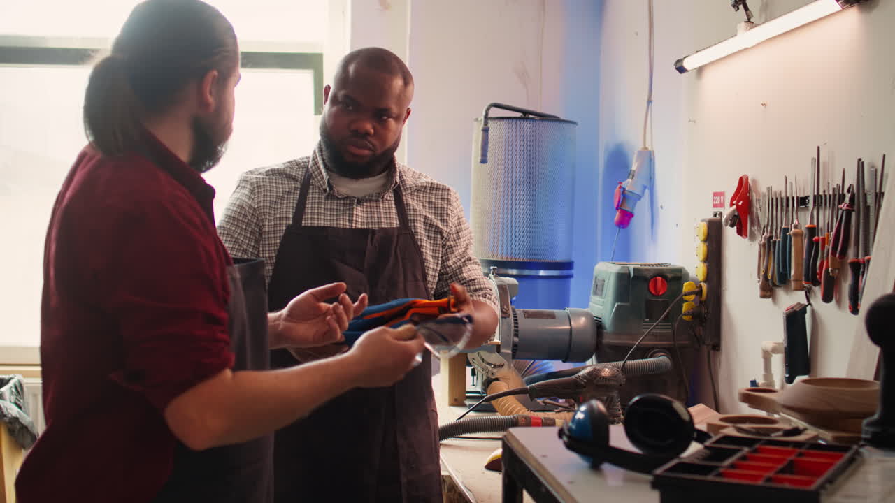 Master in woodworking shop giving worker protection gloves