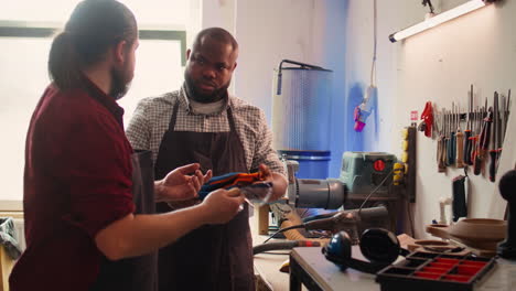 maestro en el taller de carpintería dando guantes de protección al trabajador