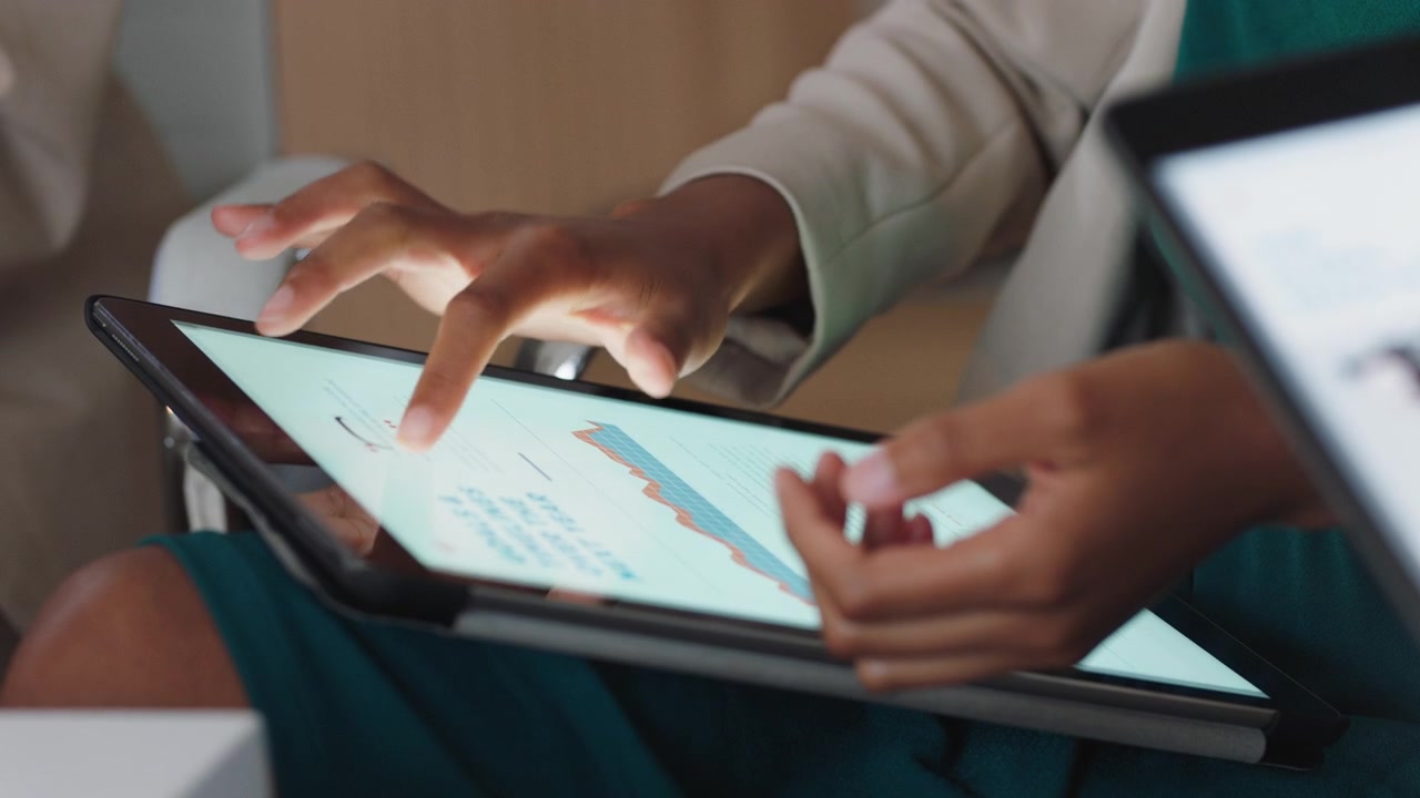 Businesswoman Analyzing Financial Data on a Tablet in an Office