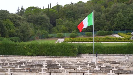 red, white and green italian flag on skinny flagpole at polish cemetery at monte cassino, italy, static