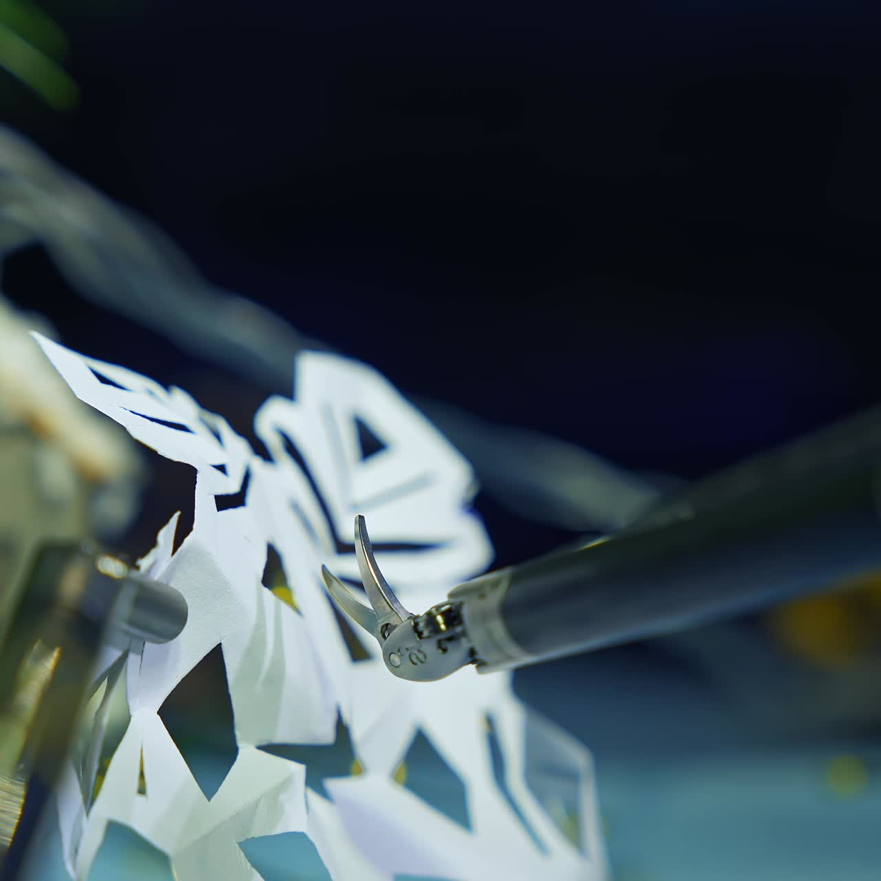 Metal cyborg preparing snowflake from paper while preparing to the Christmas. Cropped view. Robotic industry concept