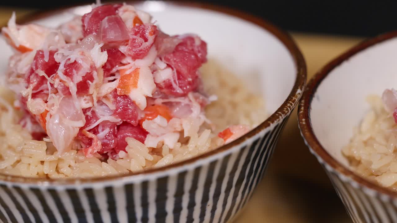 Primo piano di una ciotola di frutti di mare giapponese con granchio e tonno su riso condito