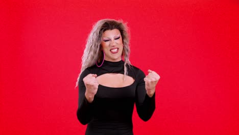 energetic drag performer in black dress on red background