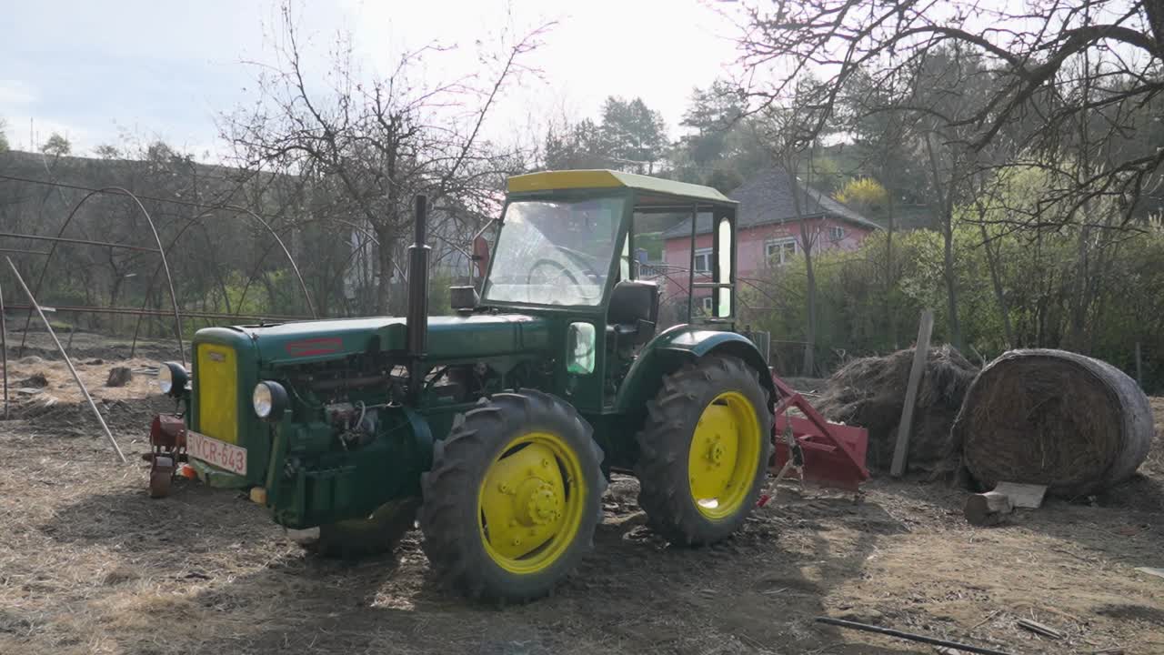 Green vintage tractor parked in rural farm environment
