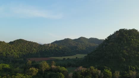 Ascending-aerial-footage-of-this-valley-and-hills-at-a-farm-land-in-Pakchong,-Khao-Yai,-Thailand