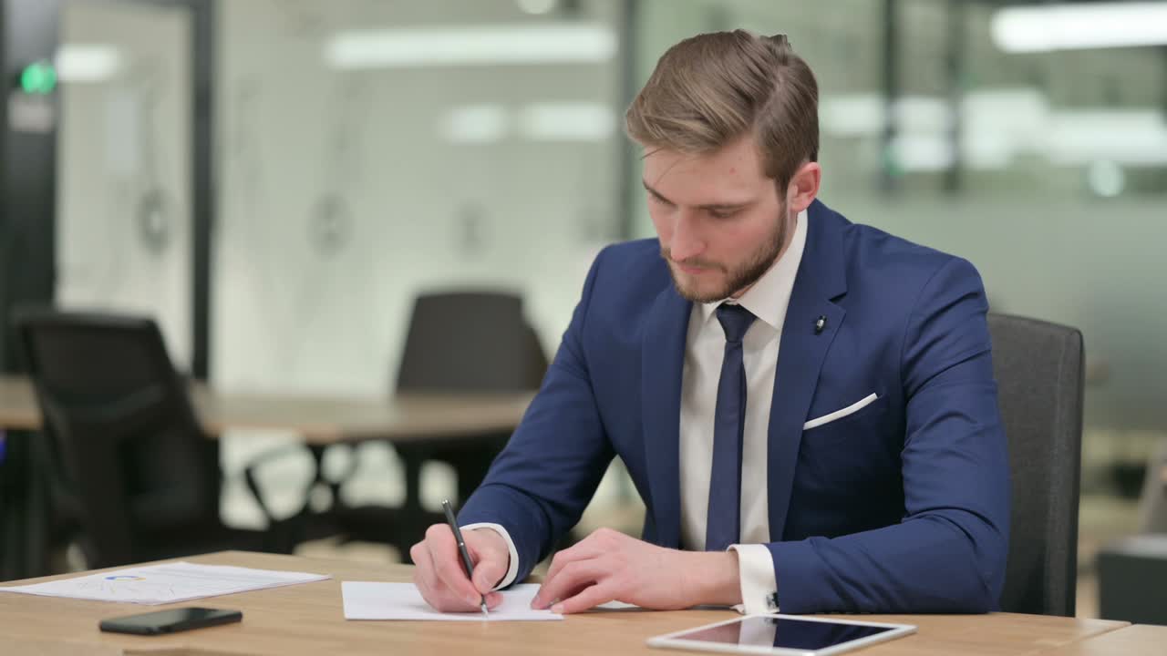 Pensive Businessman Writing on Paper, Thinking
