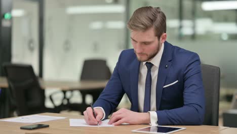 pensive businessman writing on paper, thinking