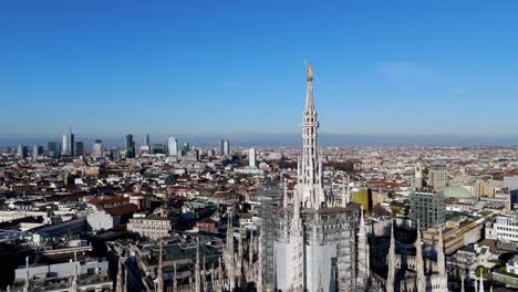 drone rotate around milan duomo cathedral revealing skyline cityscape of the city at distance , aerial sunny day european tourist city