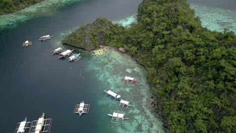 traditional boats with tourists floating and sailing at coron island in palawan, philippines