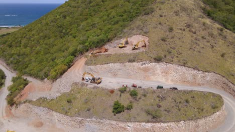 aerial view of excavators building holiday homes and hotels, on a caribbean paradise island - tilt, drone shot