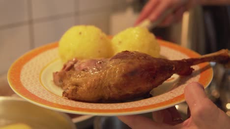 german potato dumplings and crusty leg of a goose on christmas day