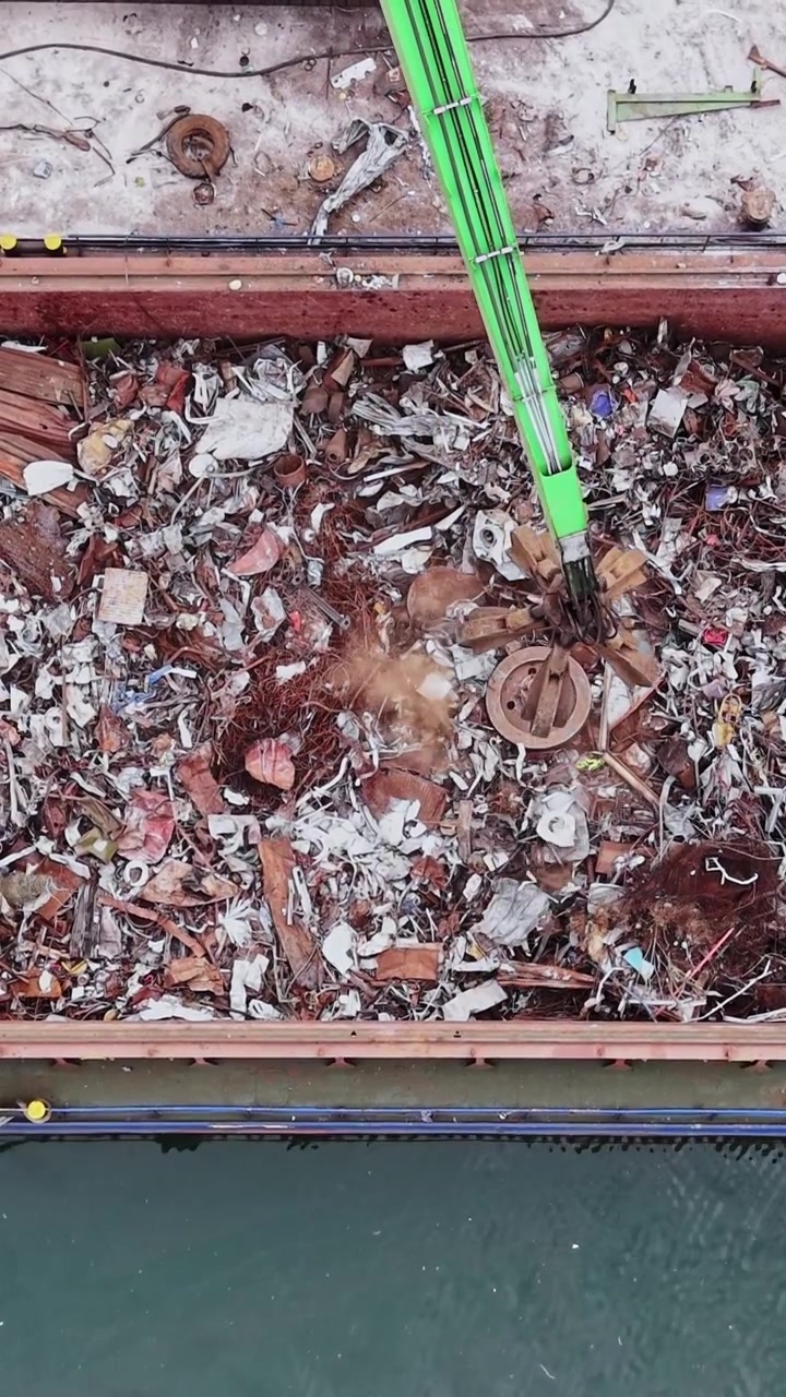 Coleta de lixo em um porto mostra atividade de remoção de detritos em um dia ensolarado.