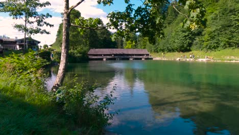 Wooden-bridge-with-roof-crossing-a-river-in-King's-Lake,-Königssee-in-Germany,-Bavaria