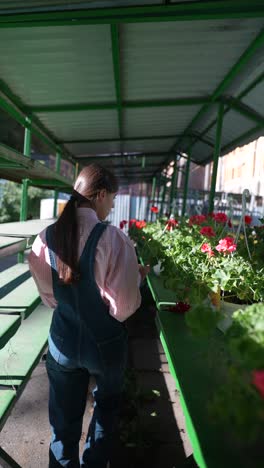 woman looking at flowers in a garden shed