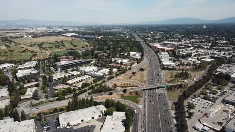 Aerial-birds-eye-view-of-Highway-101-Bridges-pivot-left-Google-campus-shoreline-amphitheater-park-Traffic