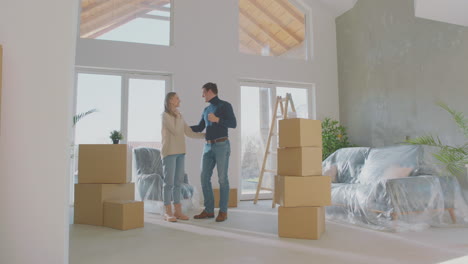 una pareja joven entrando en su nuevo apartamento.