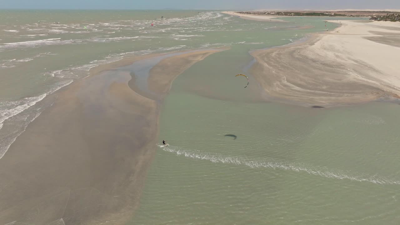 kitesurfista navegando y saltando detrás de un banco de arena cerca de guriu