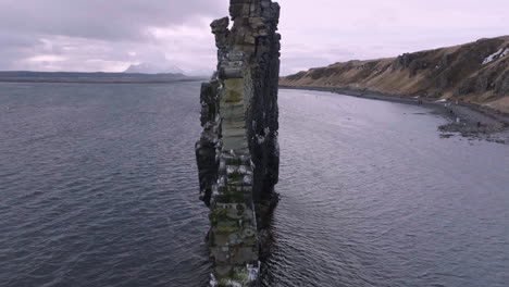 Luftaufnahme-Des-Hvítserkur-Felsens-Und-Darüber-Fliegender-Vögel,-Wahrzeichen-Islands,-Umlaufender-Drohnenschuss