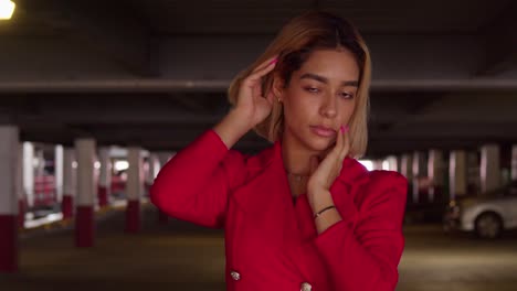 Within-the-city's-parking-structure,-a-young-Hispanic-girl-captures-attention-in-her-short-red-dress