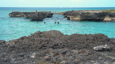 Grand-Cayman,-Smith's-Barcadere,-Two-swimmers-dive-off-rocks