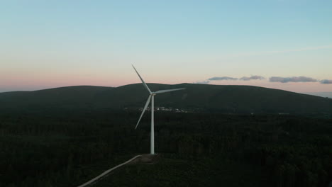 Funktionierende-Windkraftanlagen-Mit-Bergkämmen-Im-Hintergrund-Bei-Ruhigem-Sonnenuntergang-In-Serra-De-Aire-E-Candeeiros,-Leiria,-Portugal
