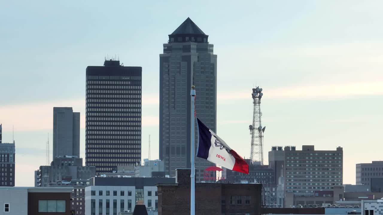 Iowa flag waving in front of Des Moines skyline